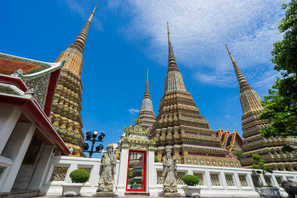 Ancient Stupas and pagoda in Wat Pho temple in Bangkok Thailand with blue sky and clouds. Traveling in Bangkok Thailand